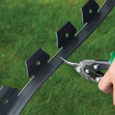 EasyFlex No Dig 20 ft. L Plastic Black Landscape Edging Kit being cut with a pair of snips.