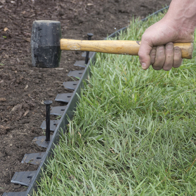 EasyFlex No Dig 20 ft. L Plastic Black Landscape Edging Kit being hammered into the ground with a mallet.