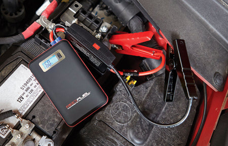 DieHard Automatic 12 V 600 amps Battery Jump Starter shown in use on a car battery.
