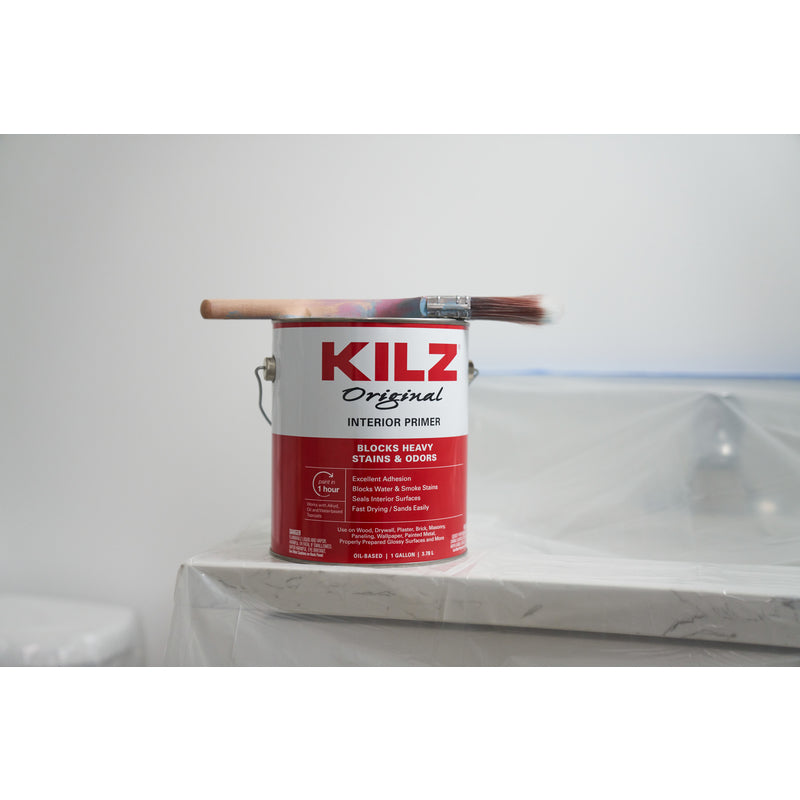 Kilz Original Primer/Sealer Gallon Can with a paint brush on top.