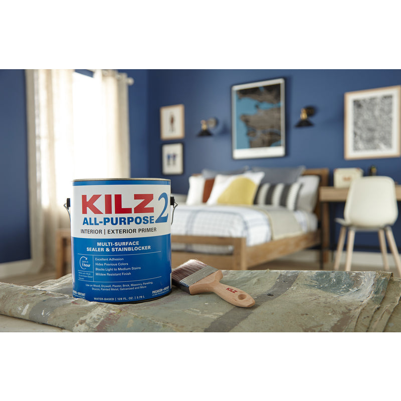 Kilz 2 All Purpose Interior Exterior Primer Can on a drop cloth with a paint brush next to it.