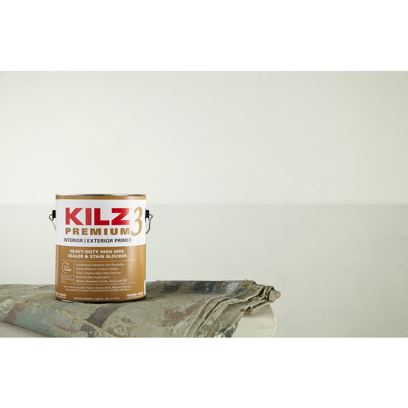 Kilz Premium Primer/Sealer Gallon Can on a drop cloth in front of a plain white wall.