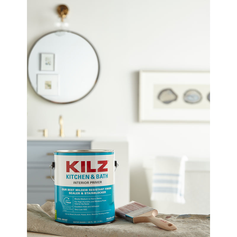 KILZ Kitchen & Bath White Flat Water-Based Primer and Sealer Gallon Can shown on top of a drop cloth with a paint brush.