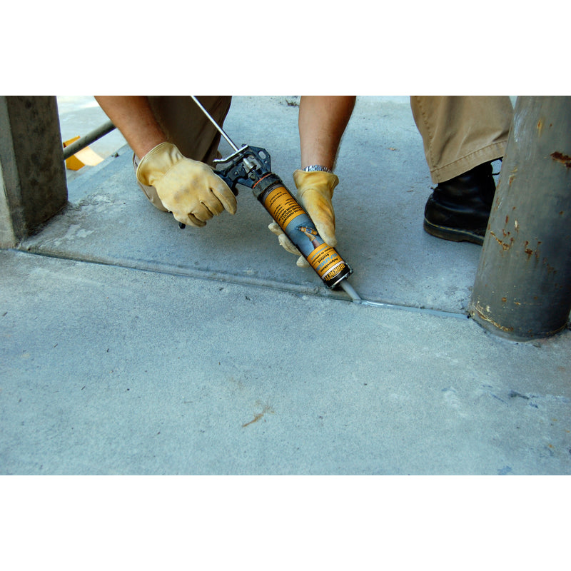 Quikrete Gray Polymer Concrete Self-Leveling Sealant being applied to a gap in sidewalk.
