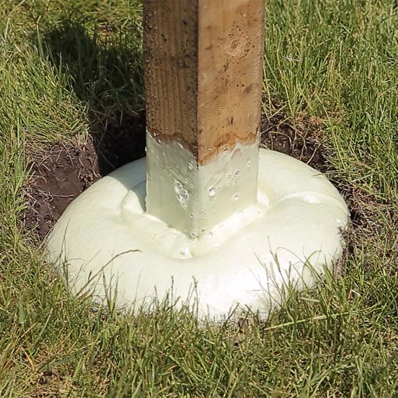 Sika Pro Select Fence Post Mix shown around the bottom of a fence post in grass.
