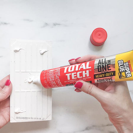 The Original Super Glue Total Tech Construction Adhesive Sealant being applied to the back of a tile.