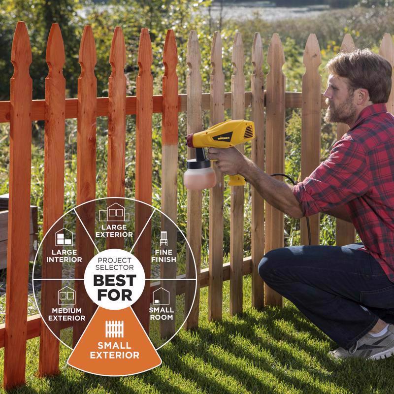 Man applying stain to a wooden fence with a paint sprayer.