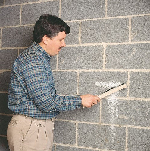 UGL Drylok Etch 01908 being applied with a brush on a concrete block wall.