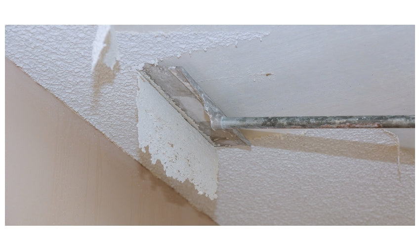 Popcorn ceiling finish being removed with a scraper