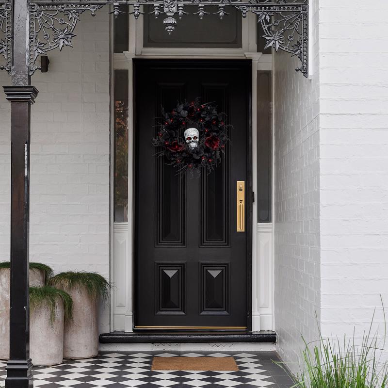 Black front door with Halloween wreath on a white building exterior