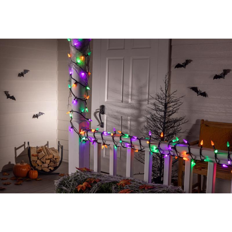 Halloween-themed room with string lights, pumpkins, and decorative bats.
