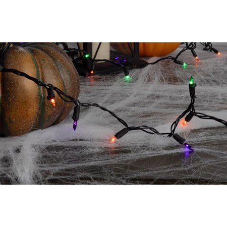 Halloween-themed string lights on a spiderweb with pumpkins