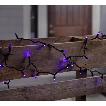 Halloween purple string lights on a wooden surface with a blurred background