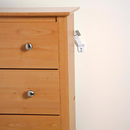 Wooden dresser with two drawers and metal handles secured with the Safety 1st Furniture Wall Straps 2-Pack 11014 on a white background