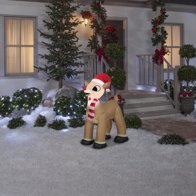 Inflatable reindeer decoration in front of a house with Christmas decorations.