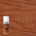 A can of Varathane Premium Fast Dry Wood Stain in the Cognac colorway, positioned in the lower-left corner against a large wood grain background showing the stained finish.