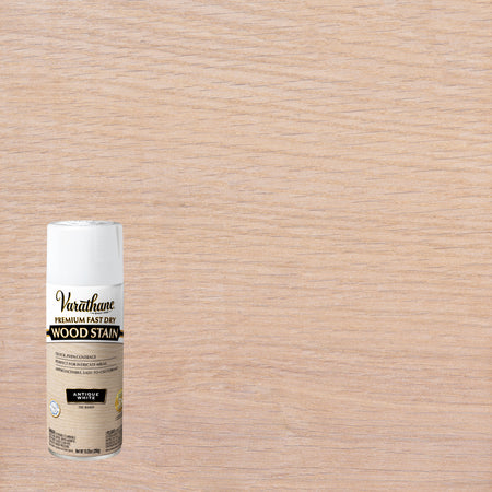 A can of Varathane Premium Fast Dry Wood Stain in Antique White finish, shown against a large wood grain surface that demonstrates the stain's effect.
