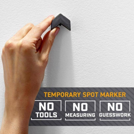 Hand using a temporary spot marker on a white wall with promotional text.