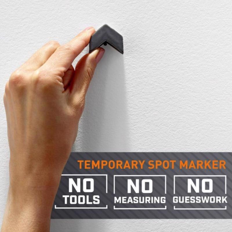 Hand using a temporary spot marker on a white wall with text indicating no tools, measuring, or guesswork.