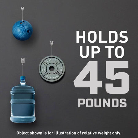Three objects hanging from a string with text indicating weight capacity of 3M CLAW on a dark background