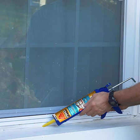 Person applying Sikaflex Construction Sealant to a window seal with a caulking gun.