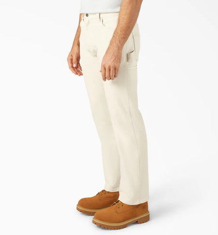 Person wearing Dickies Natural Relaxed Fit Painter's Pants and brown shoes on a white background