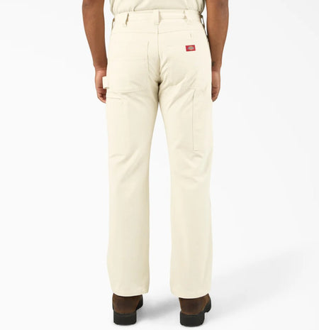 Rear view of person wearing Dickies Natural Double Knee Relaxed Fit Painter's Pants with a Dickies logo on a white background