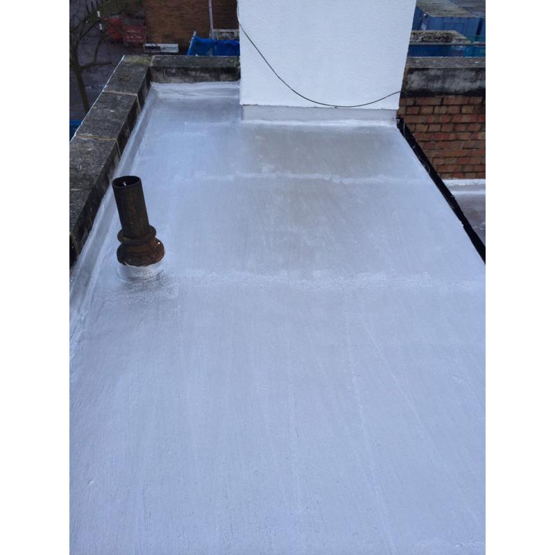 Flat roof with Aluma-Kote waterproofing membrane and a pipe, with a brick wall background.