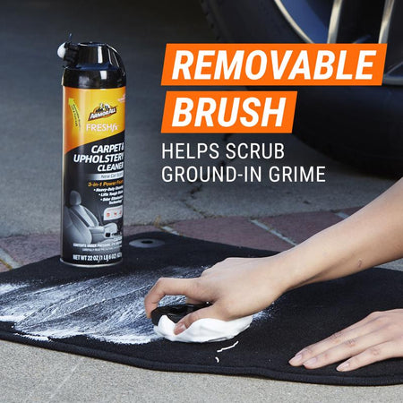 Scrubbing a car floormat with Armor All FreshFx Carpet and Upholstery Cleaner.