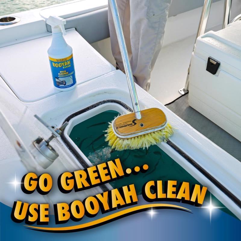 Boat cleaning setup with Booyah Clean product and cleaning brush on a boat deck.