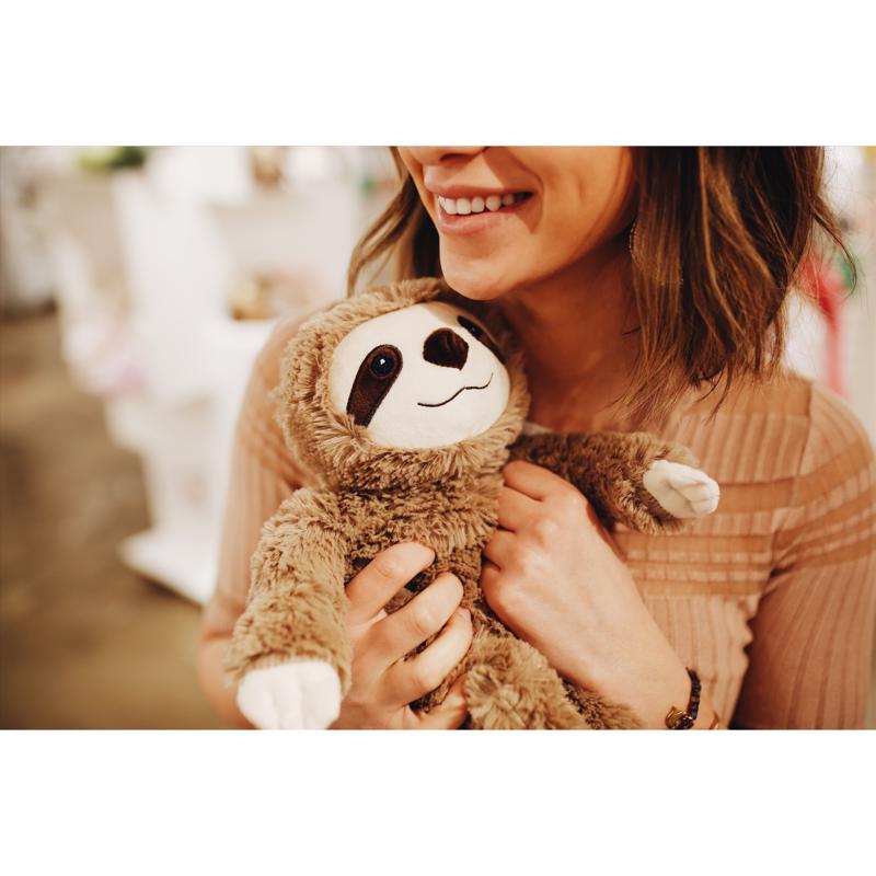 Person holding the Warmies CP-SLO-1 Plush Stuffed Sloth with a blurred background