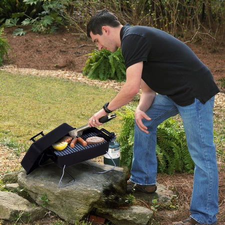 Man cooking food on the Char-Broil 1 Burner Liquid Propane Portable Grill 465133010