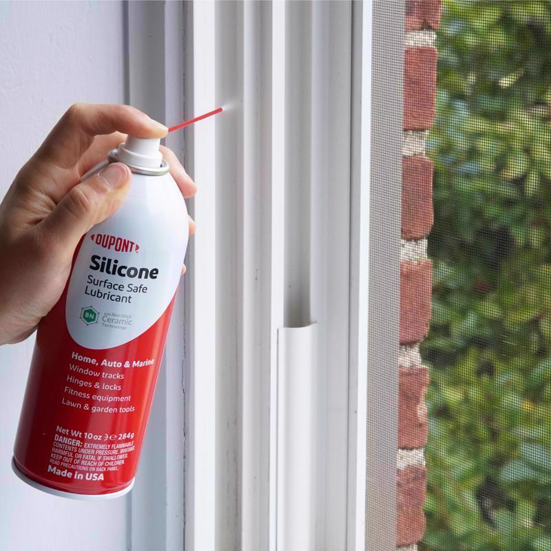 Person using a DuPont silicone lubricant can on window tracks.