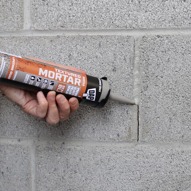 DAP Premium Textured Mortar Elastomeric Latex Filler & Sealer being applied between gap in concrete block wall.