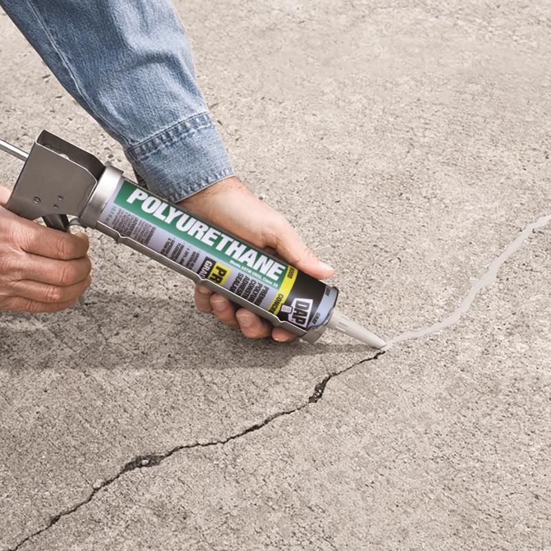 DAP 10.1 oz. Gray Polyurethane Waterproof Concrete Sealant being applied to crack in concrete slab.