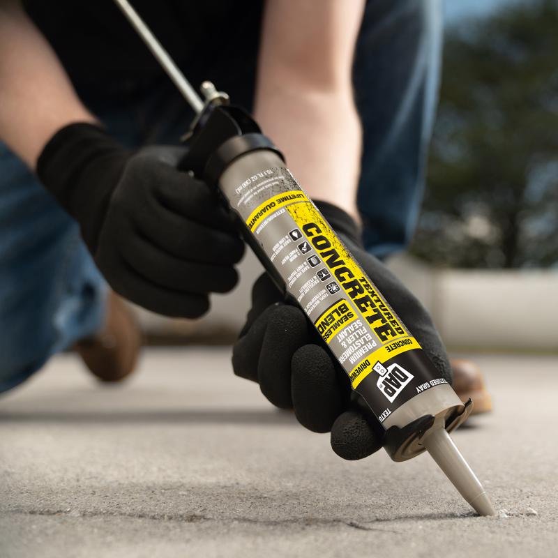 DAP 10.1oz Premium Textured Concrete being used to repair a crack on concrete sidewalk.