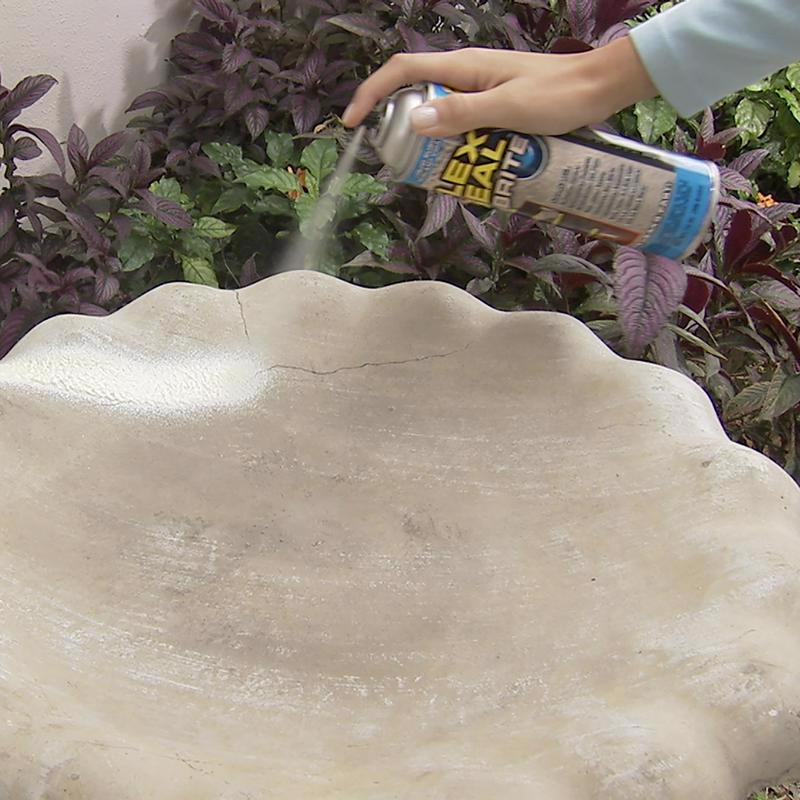 Person using Flex Seal Brite on a stone surface with plants in the background