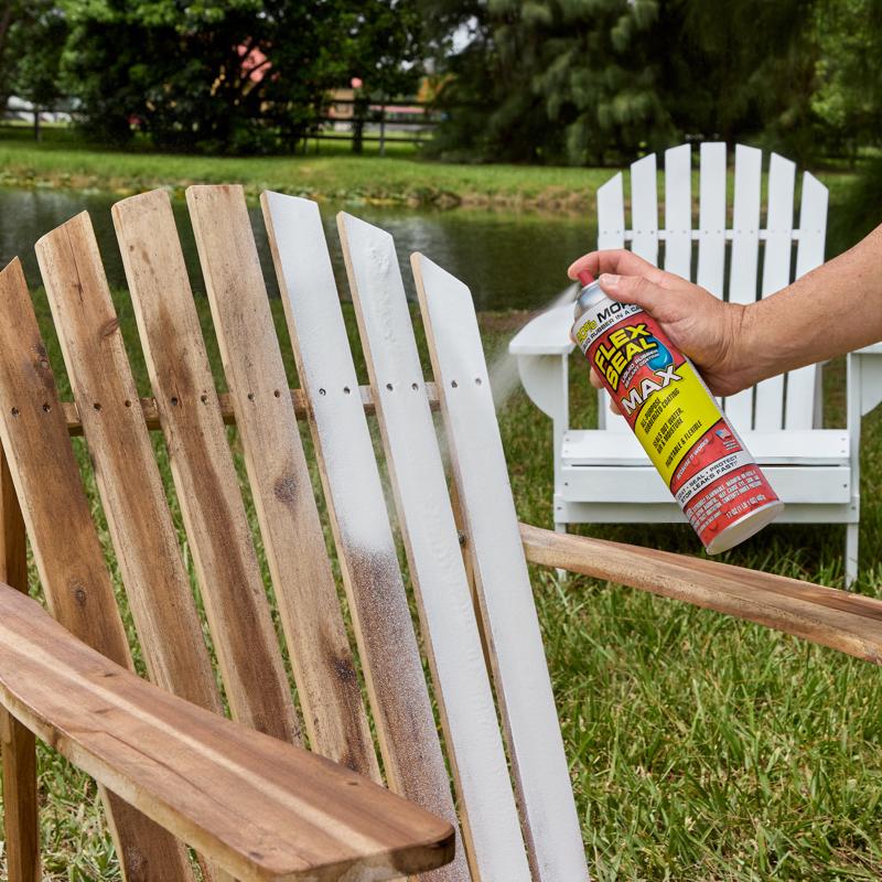 Person using Flex Seal Max on a wooden chair outdoors by a lake.