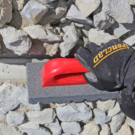 Person using the gator silicon carbide rubbing brick on mortar.