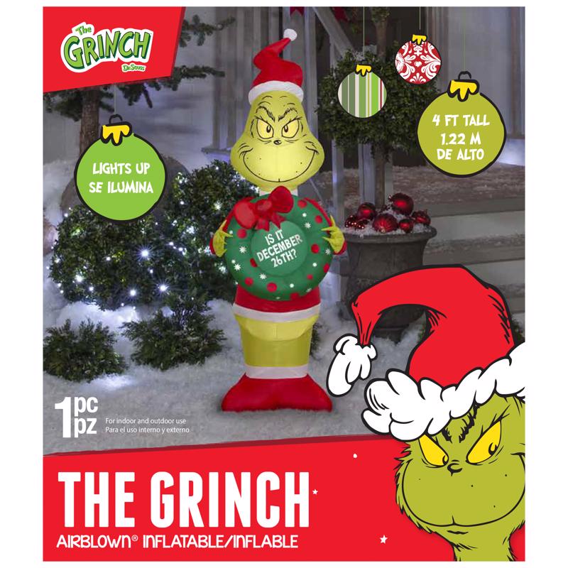 Grinch inflatable decoration with packaging, featuring text and graphics.