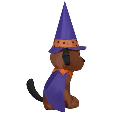 Side view of dog inflatable with witch hat and cape on a white background