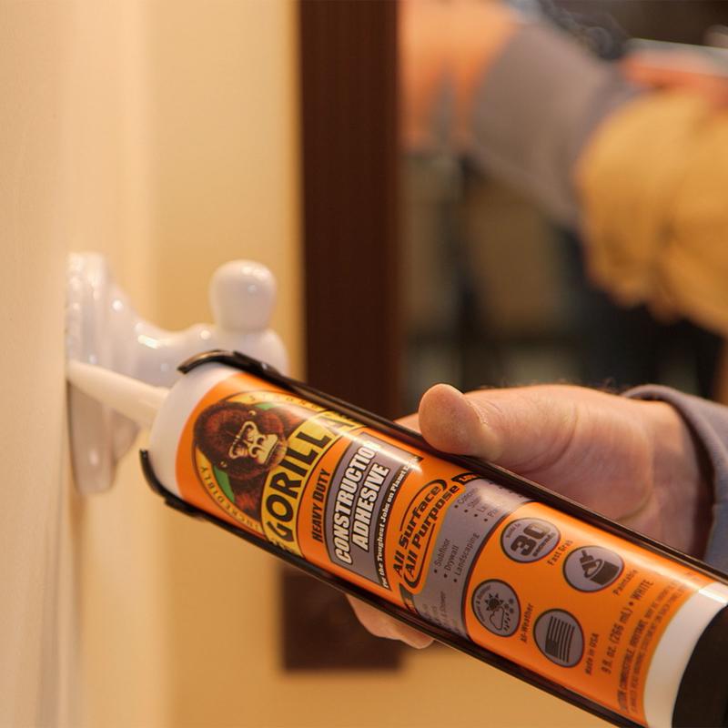 Gorilla Heavy Duty Construction Adhesive being applied to a hook on a wall.