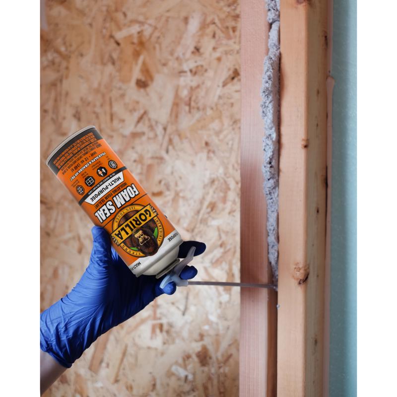 Spraying Gorilla Glue Gray Foam Seal Multipurpose Insulating Sealant 112361 in a wood gap