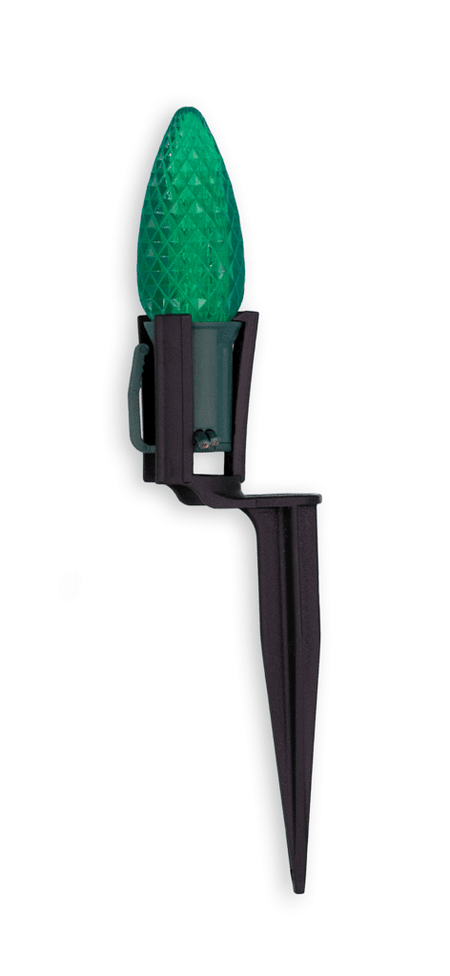 Green LED light bulb on a black spike against a white background