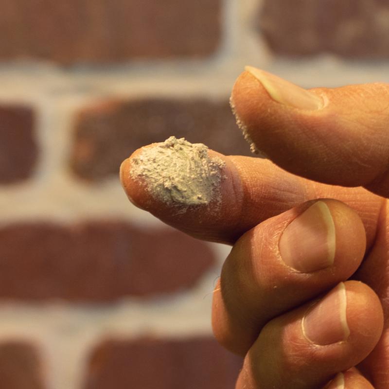 Sashco 10.5 Oz Mor-Flexx Mortar & Stucco Repair Sealant on fingers showing the consistency of the product.