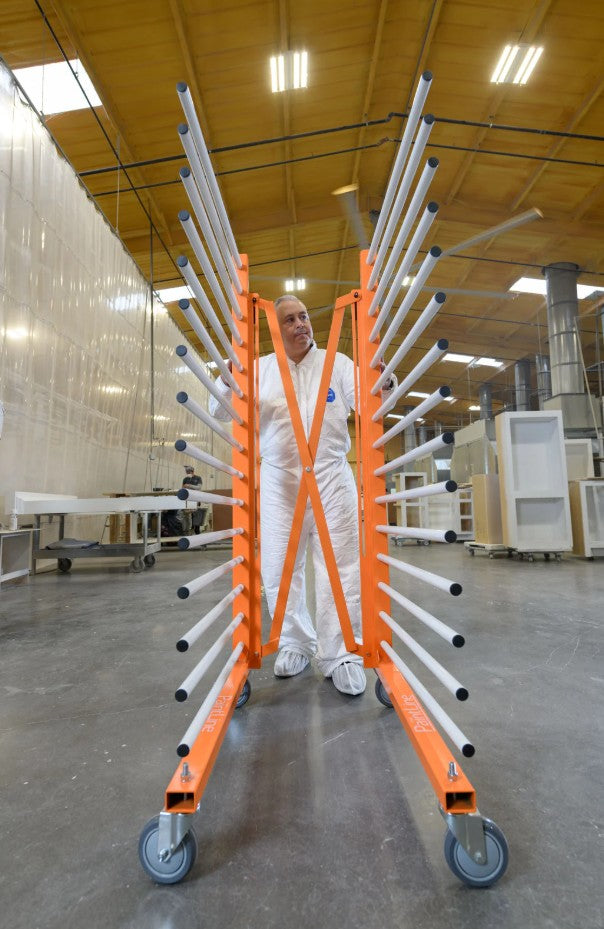 Person standing next to a folded PaintLine PDREX in a warehouse.