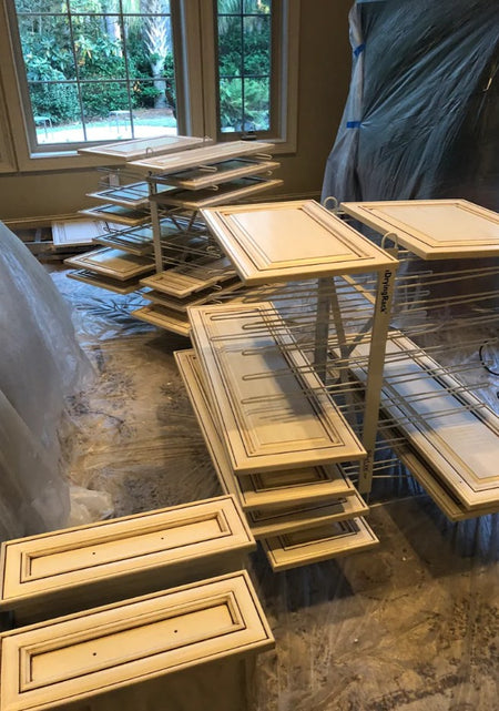 Stacks of wooden cabinet doors shown on two PaintLine PDRTT Drying Racks
