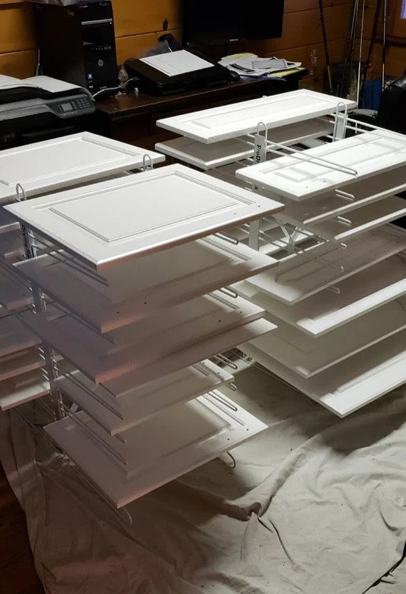 Two PaintLine PDRTT Drying racks holding white cabinet doors