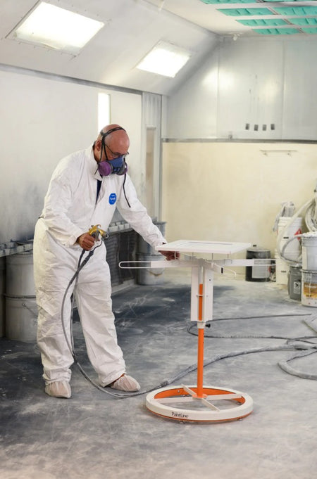 Person in a spray booth with protective gear using the PaintLine SPTYHD SprayTwirlyHD 