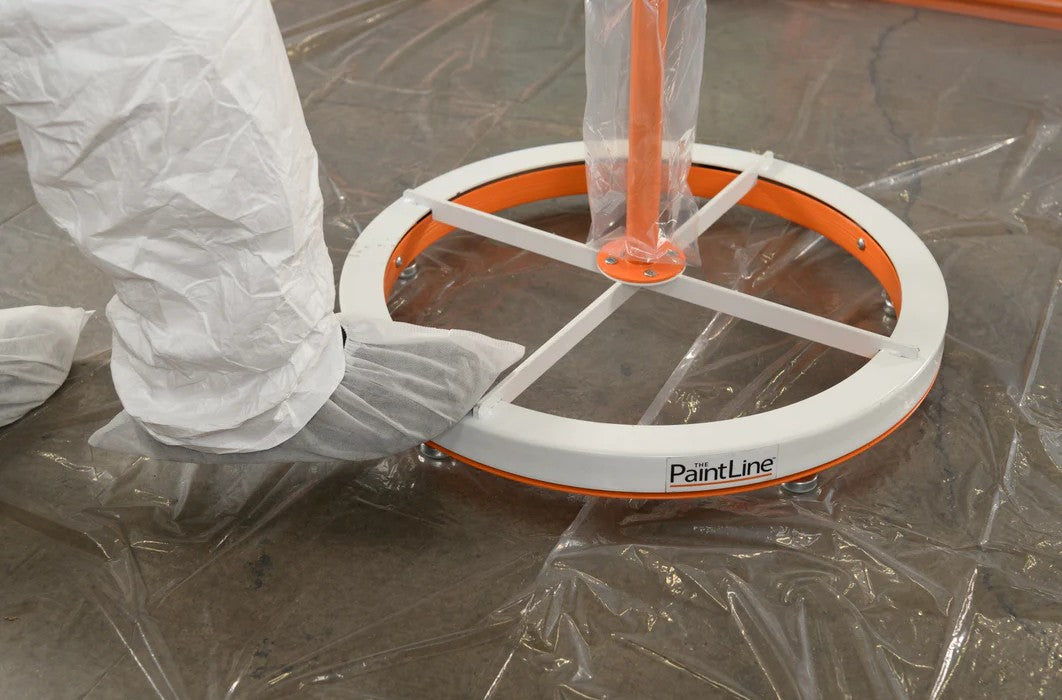 Close up of the foot operated turntable of the PaintLine SPTYHD Rotating Spray Table being used by a man in a spray suit